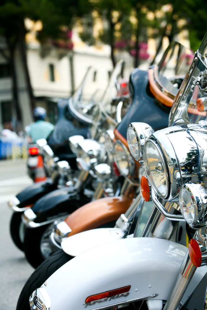 hero-services Close-up of gleaming chrome motorcycles parked on an urban street, showcasing their shiny headlights.