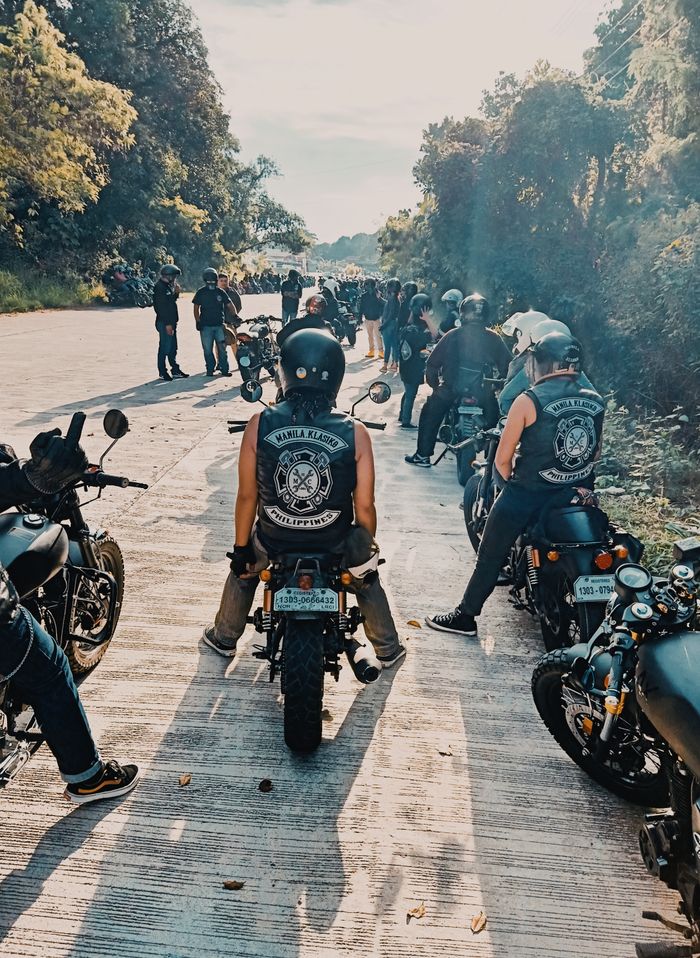 services-01 Motorcyclists gather on a sunny road for a group ride, showcasing camaraderie.