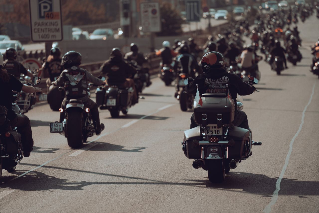 A large group of motorcyclists riding their bikes down a city highway, showcasing a sense of freedom and adventure.